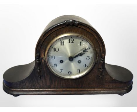 An early-20th century oak eight day mantel clock with silvered dial, width 50cm.