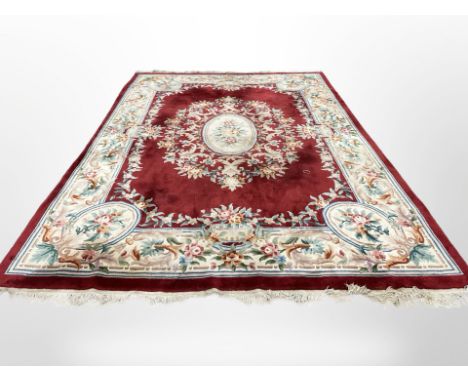 A Chinese carpet on red ground, 375cm by 278cm