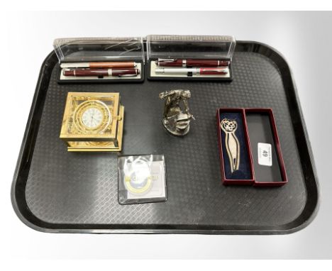A brass Sewills mantle clock together with silver page keeper, white metal blacksmith figure, Westminster five pound coin and