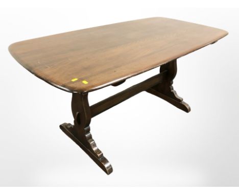 An Ercol stained elm 5' dining table and a set of four spindle back chairs. 