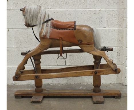 A 19th century rocking horse, stripped of paint, with glass eyes, later harness and horse hair mane, on safety rocker, 96cm h