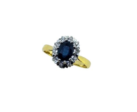 A late 20th century 18ct gold sapphire and diamond cluster ring, claw set oval faceted sapphire, approximately 6.8 x 5.2mm, e