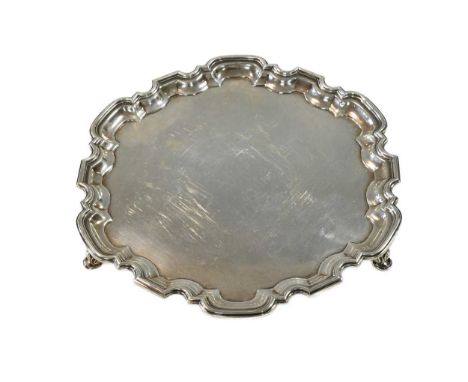 A George VI silver salver, mark of the Goldsmiths' &amp; Silversmiths' Company, London 1937, 'Chippendale' style, raised on t