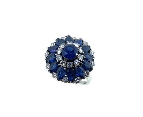 A late 20th century sapphire and diamond cluster ring, claw set round faceted sapphire, diameter approximately 5.75mm, surrou