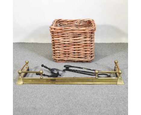 A wicker log basket, 59cm, together with a brass fender and a set of fire tools