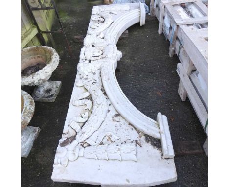 A large carved white marble architectural arch, decorated with swags and masks, 250cm wide
