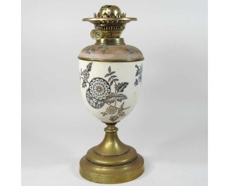 A Victorian oil lamp base, the textured stoneware body decorated with flowers, on a brass base, 38cm high