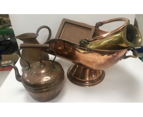 A collection of various metal wares to include copper coal helmet x 2, copper kettle, embossed conical water jug, copper hays