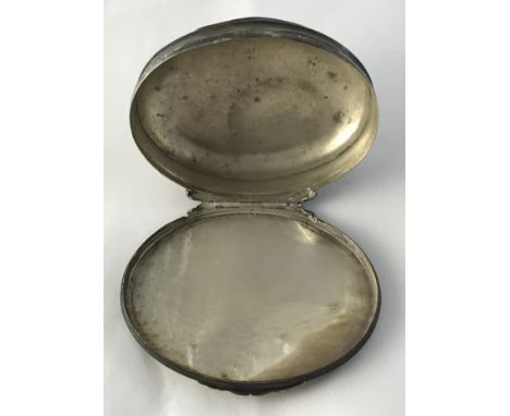 A late 18th / early 19th Century white metal and mother of pearl mounted snuff box of oval form, the hinged lid with carved f