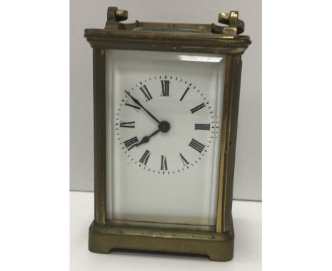 A circa 1900 French brass cased carriage clock, the enamelled dial with Roman numerals to the chapter ring, raised on plain b