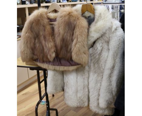 A white fox fur jacket and brown fox cape