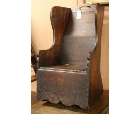 A 19th century oak child's rocking armchair with commode seat