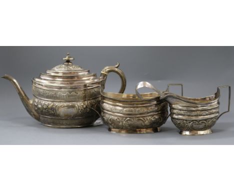 A matched George III silver embossed three piece tea set, London, 1802 and later, teapot by Urquhart &amp; Hart and a pair of