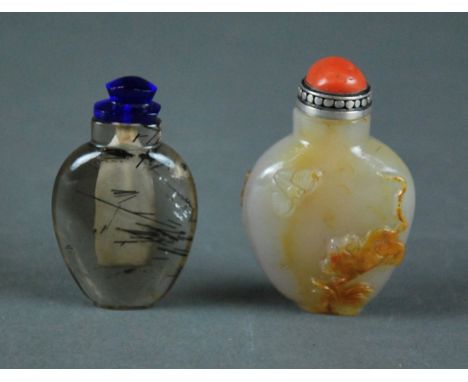 TWO CHINESE CARVED SNUFF BOTTLES Comprising a 'hair crystal' bottle of ovoid form with rounded shoulders and a carnelian agat