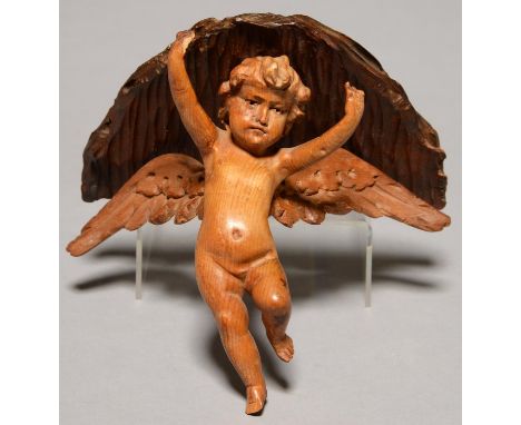 A CONTINENTAL CARVED LIMEWOOD WALL BRACKET IN THE FORM OF A CHERUB, LATE 19TH C, SUPPORTING A RUSTIC STAINED LIMEWOOD SHELF, 