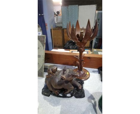 A carved wood buffalo on a stand and a lamp