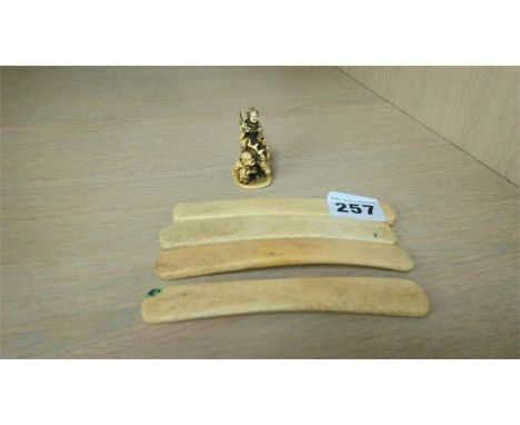 A small Japanese Ivory Netsuke, signed, of a woman riding an Elk and four bone ribs