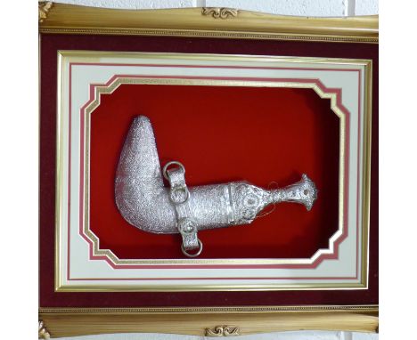 An Omani Khanjar with white metal handle and scabbard, framed