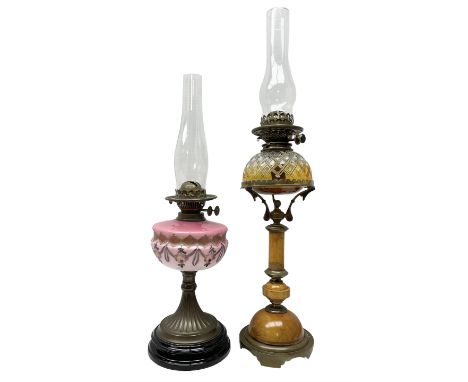 Two late 19th/early 20th century oil lamps, comprising example with pink glass reservoir painted with roses, together with oa