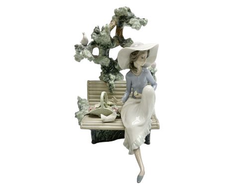 Lladro figure, Sunday in the Park, modelled as a woman sat on a bench under a tree, sculpted by Antonio Ramos, no 5365, year 