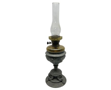 Victorian cast spelter oil lamp, decorated with cherubs and foliate scrolls, supporting a glass reservoir, burner and clear g