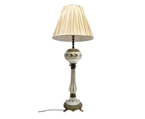 Table lamp in the form of a Victorian oil lamp, the cast metal base with four lion mask and paw feet, leading to a milk glass