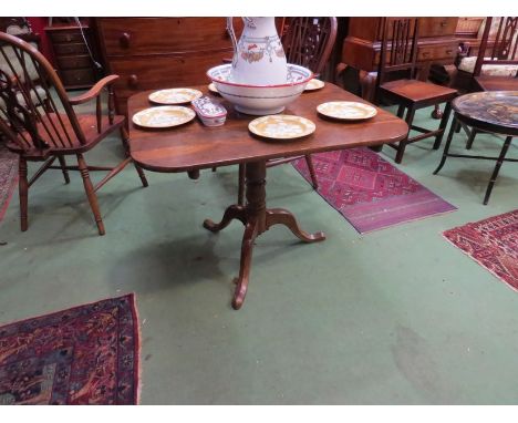 A Victorian oak tilt-top table on tripod feet 