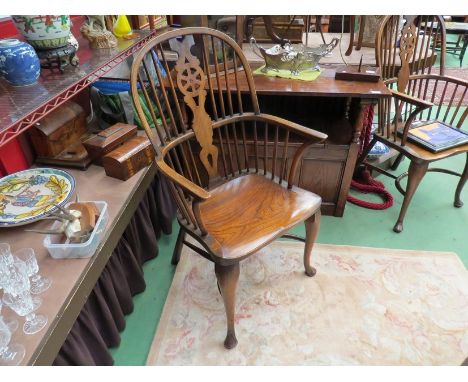 A pair of elm stick and wheel back elbow chairs with crinoline stretchers on pad front feet