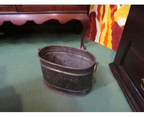 An embossed oval coal bucket with ring handles and foliate detail, 25cm tall