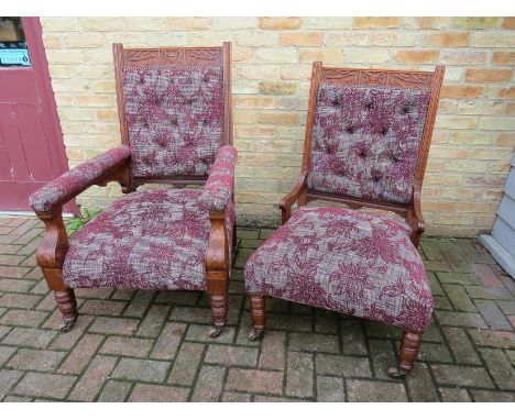 A pair of Victorian walnut his and hers armchairs, the carved urn crest over foliate upholstery to back and seat, ring turned