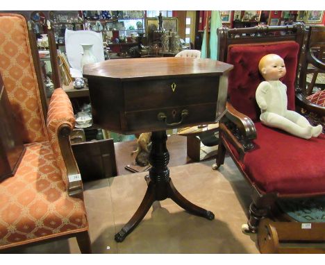 A George III mahogany worktable the canted corner top and single frieze drawer over a ring turned column on a tripod base and