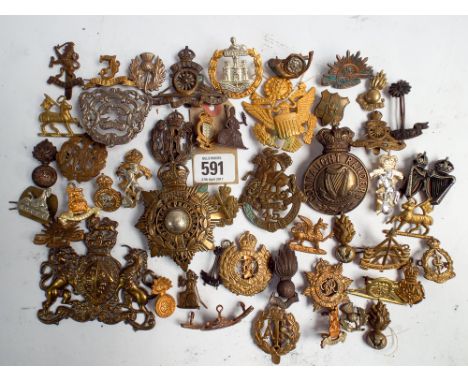 A collection of approximately 50 military cap badges, helmet plates, insignia etc to include the Royal Marines, Royal Enginee