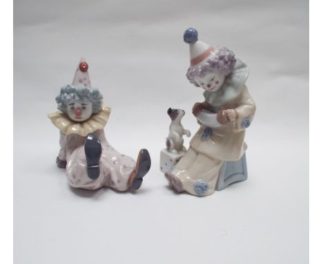 Two Lladro figures of child clowns, one playing accordion with a puppy, the other reclining.  Approx 6.5" tall - both with bo