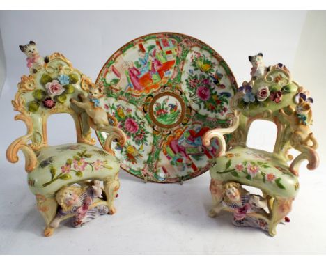 Two Dresden coloured bisque armchairs with floral encrustations modelled as children playing with cats, together with famille