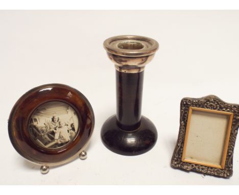 Miniature silver photograph frame, tortoiseshell circular frame and a wooden candlestick with silver top 
