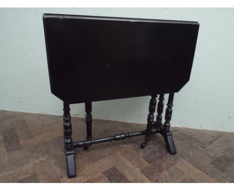 An Edwardian bobbin turned ebonised Sutherland table 61cms wide, 16cms deep