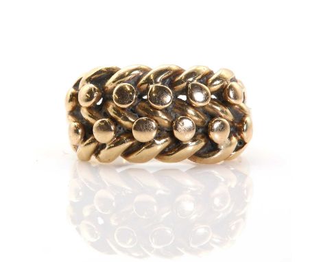 An 18ct gold keepers ring, with two rows of beads between the plaiting, to trifurcated shoulders and angled shank, Chester 19