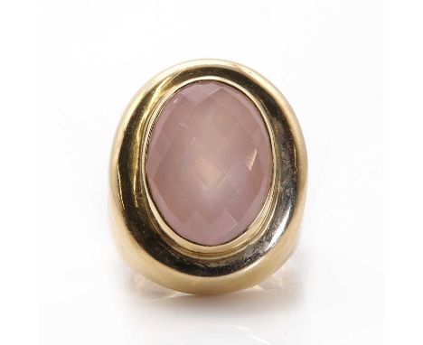 A gold rose quartz ring, an oval checkerboard cut rose quartz, 12.79mm x 17.28mm, bezel set, to an oval platform, to plain wi