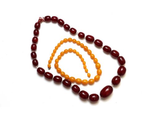 A single row cherry red faux amber bead necklace,a single row of graduated barrel shape cherry red faux amber beads, strung k