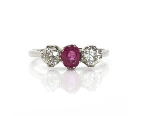 A ruby and diamond three stone ring, the oval mixed cut ruby claw set between two round cut diamonds, coronet gallery, chenie