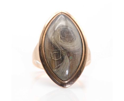 A Georgian navette shaped memorial ring, with a coiled lock of hair to a glazed cover. A slightly flared frame to flat sectio