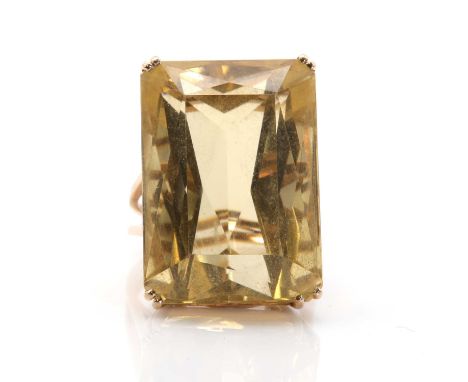 A gold single stone citrine ring, a rectangular scissor cut citrine, claw set to an open gallery, to split shoulders and a gr