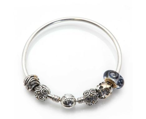 A sterling silver bangle, by Pandora, with five assorted charm beads attached, to include a 14ct gold colourless and blue gla