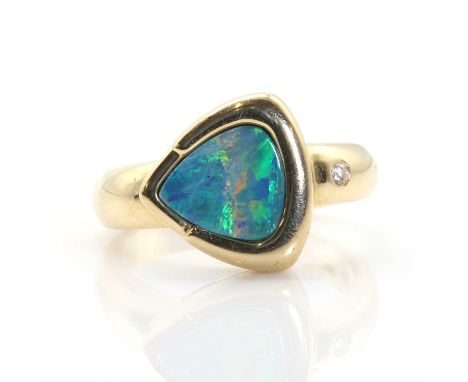 A gold single stone black opal doublet ring,  with a brilliant cut diamond Swiss set to the shoulder. Marked 585 14K. Head 12