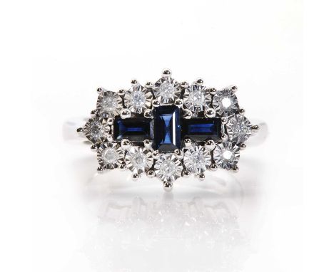 A white gold sapphire and diamond cluster ring, designed as a vertical baguette cut sapphire between two similar horizontal s