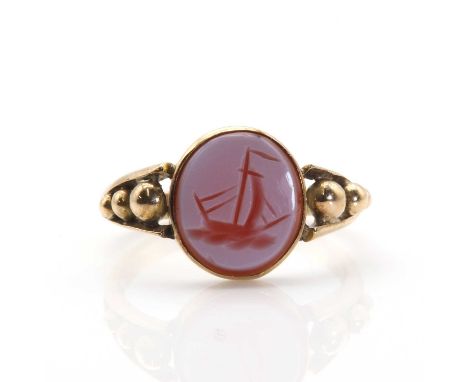 A hardstone intaglio ring,  with an oval sardonyx intaglio engraved with a sailing ship, rub set to a plain collet. Split sho