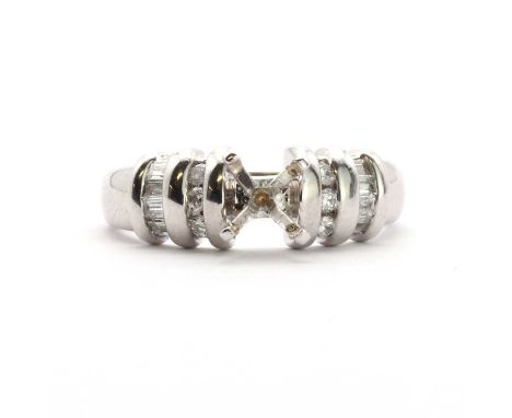 An 18ct white gold vacant ring mount, with diamond set shoulders, a four claw vacant collet to the centre, to a row of round 