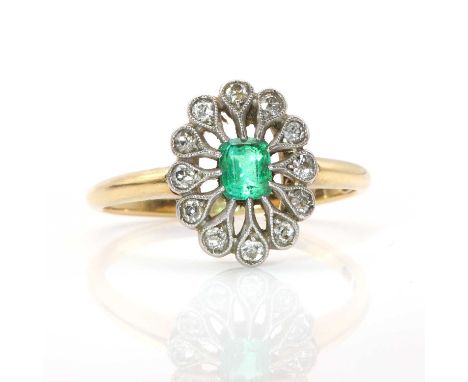 An emerald and diamond oval plaque ring, a central stepped cut emerald claw set to a radiating surround of old eight cut and 