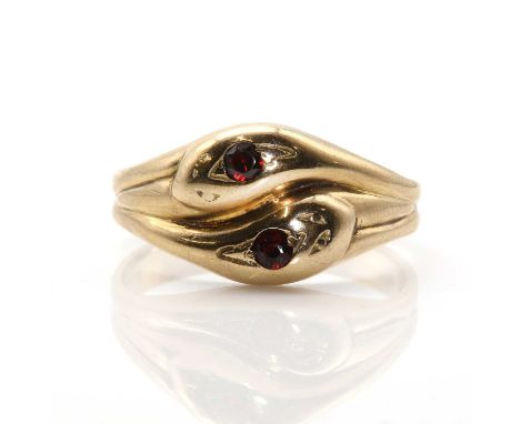 A 9ct gold and garnet entwined snake ring, two circular mixed cut garnets, rub set to entwined coiled snakes with crossover h