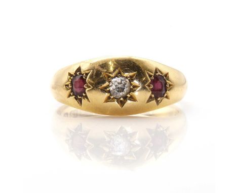 An 18ct gold diamond and garnet three stone ring, the cushion shaped diamond between oval cut almandine garnets, all star set